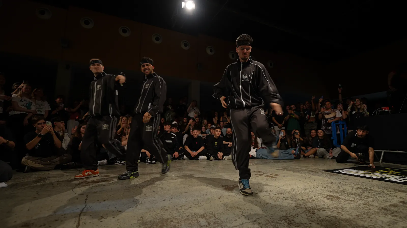 Two dancers on the floor under a spotlight, facing the crowd