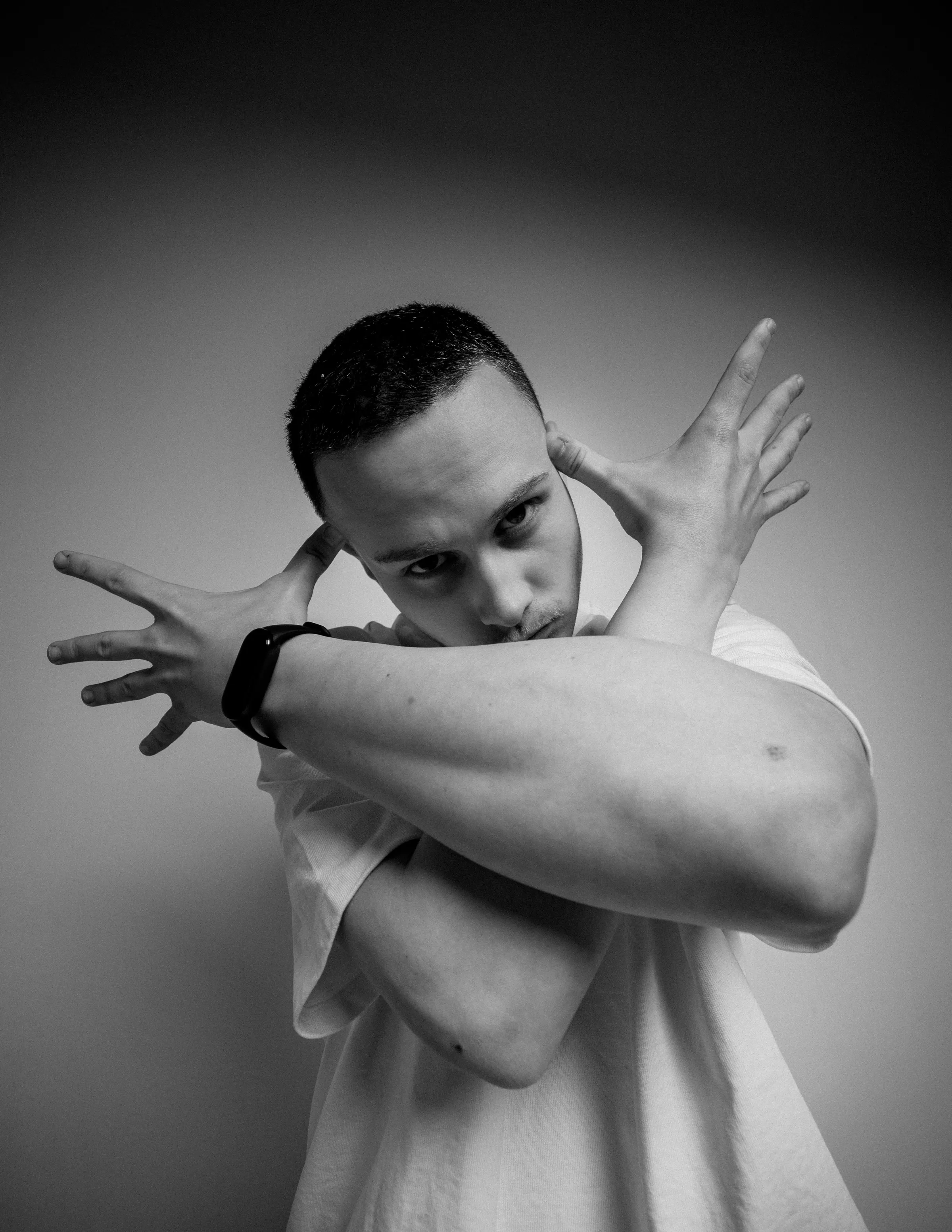 Black and white portrait of Niki with open hands beside his head