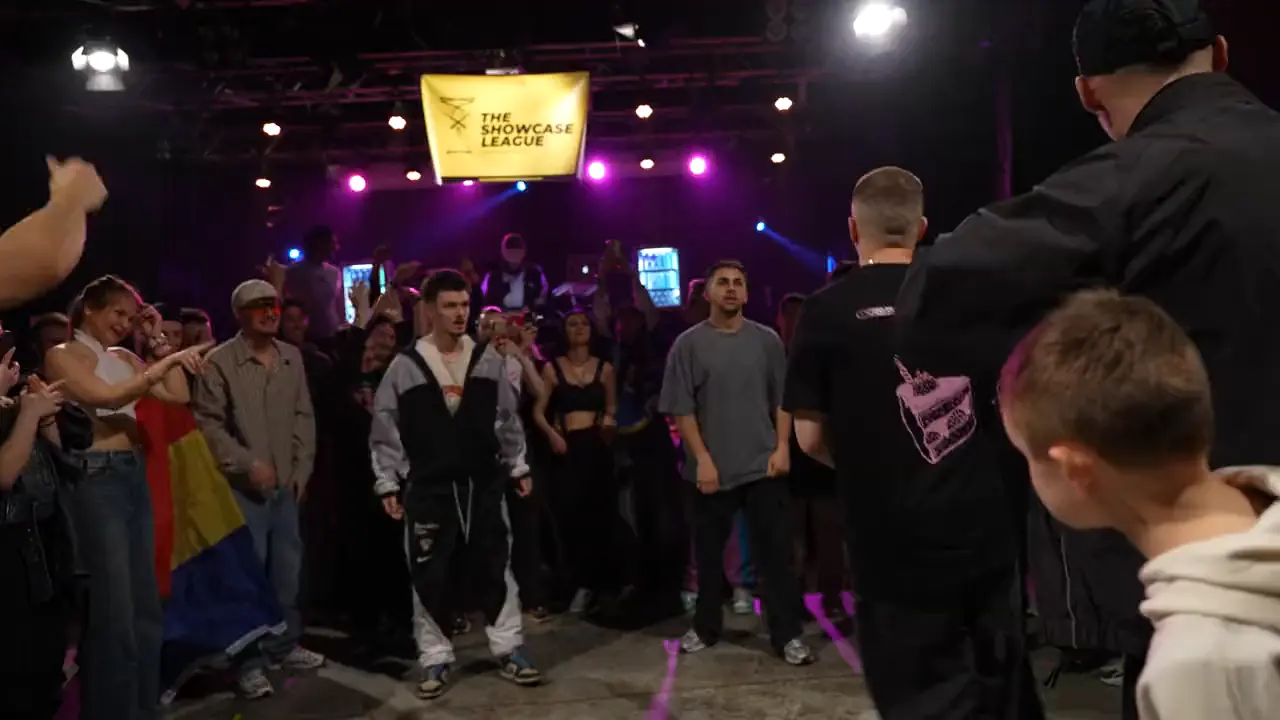 A battle circle in a club, purple lights and a tight crowd